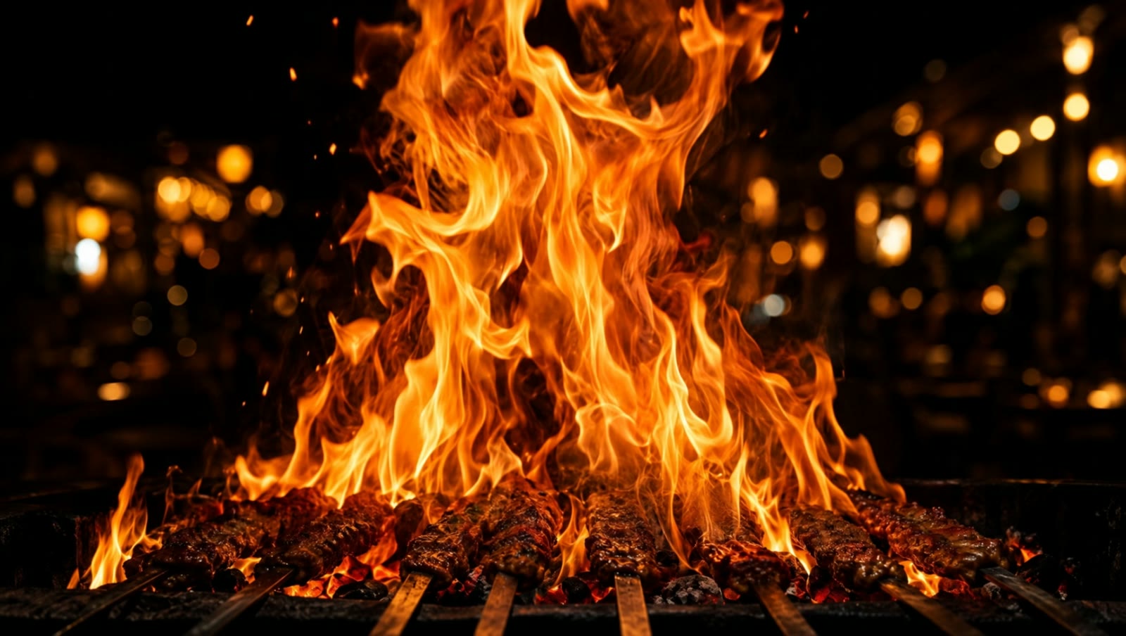 Tall flames rising from a charcoal kabob grill